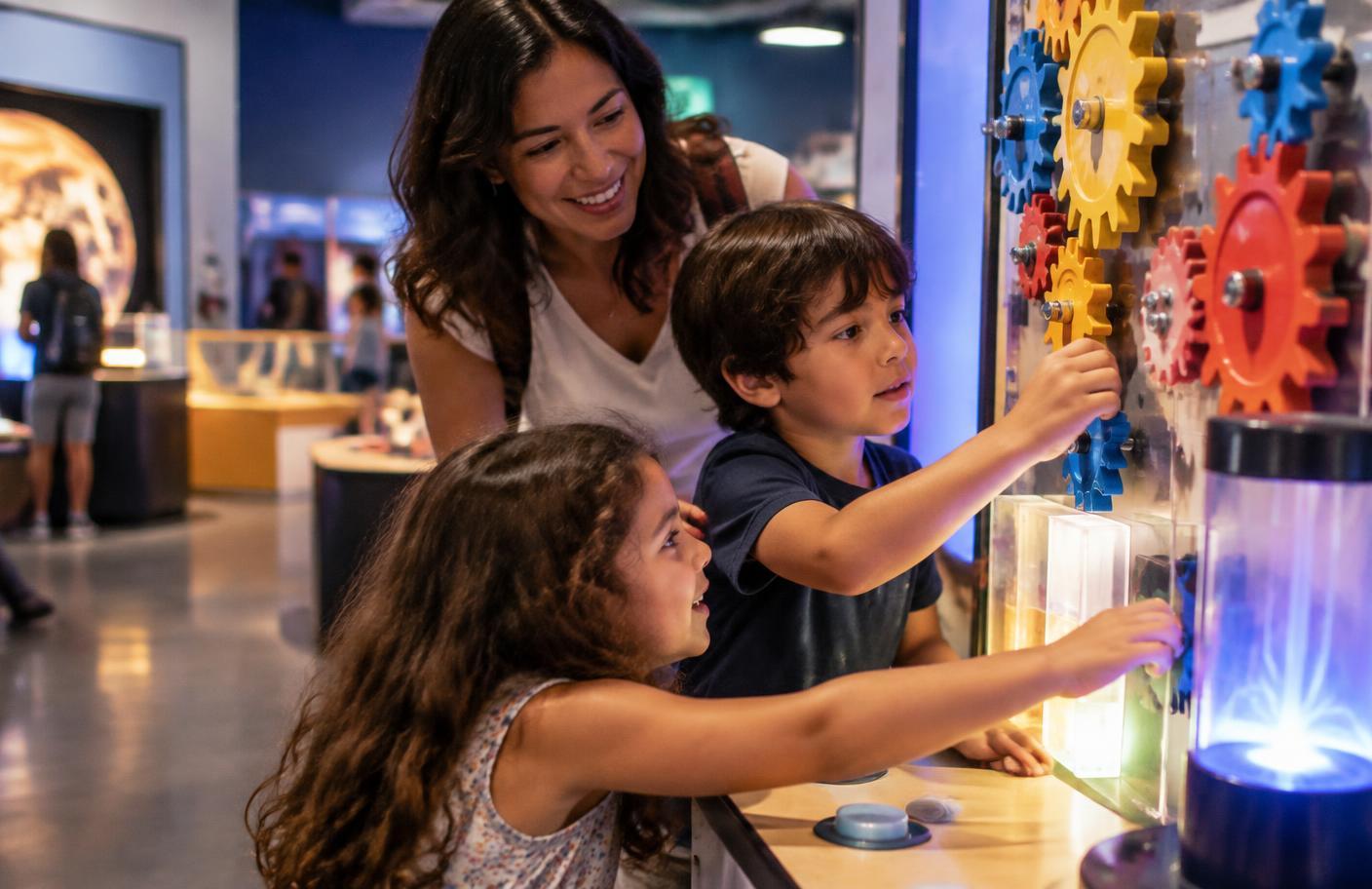 Crianças explorando instalações interativas em museu de ciência